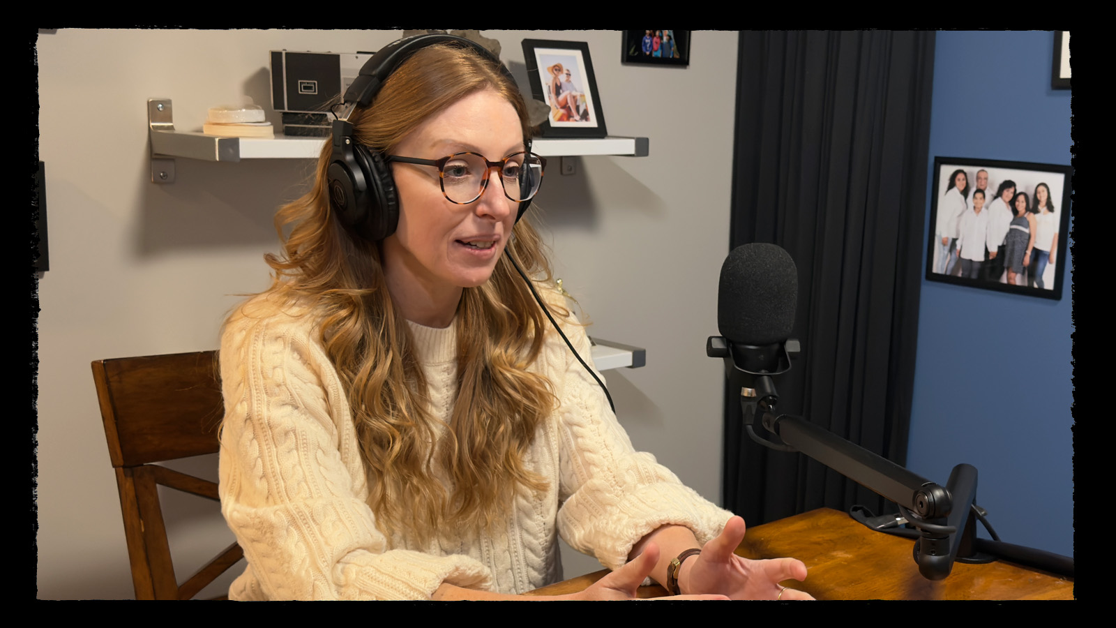 Dr Ciera Fox talking with her hands at the microphone during an OverArch Podcast recording.